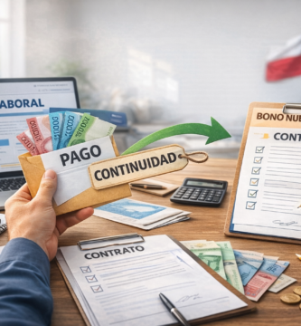 Escritorio de oficina con documentos, contrato, dinero chileno y computador, representando la comparación entre IFE Laboral y Bono Nuevo Empleo en Chile.