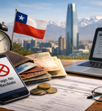 Celular con aviso de pago no recibido, billetera, dinero y documentos sobre una mesa con vista a Santiago de Chile