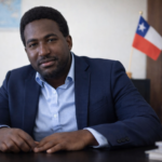 Stevenson Jacques en oficina, en formato horizontal, como imagen principal de la página de extranjería en Chile.